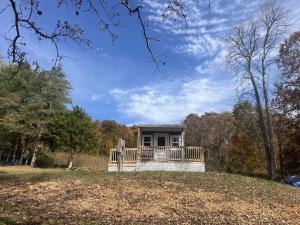 een huis op een heuvel met een veranda bij Charming Tiny Home Studio Sleeps 2 - Grill - Porch in Acuff