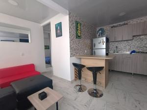 een woonkamer met een rode bank en een keuken bij Apartamento en Ibagué Campestre in Ibagué
