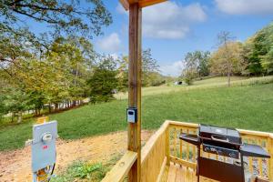 a grill on a wooden deck with a view of a field at Charming Tiny Home Studio Sleeps 2 - Grill - Porch in Maynardville