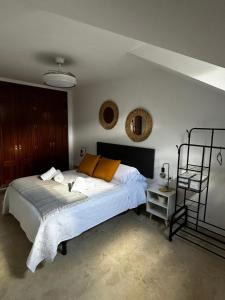a bedroom with a bed with white sheets and orange pillows at Luz del Sur in Antequera