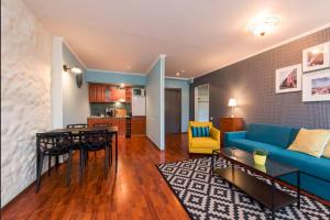 a living room with a blue couch and a table at Tallinn City Apartments Residence in Tallinn