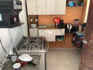 een keuken met een kookplaat en een oven bij Lindo, simples, aconchegante e pé na areia in Fortaleza