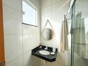 een badkamer met een wastafel en een spiegel bij Eficiência - Casa DasCli in Camocim