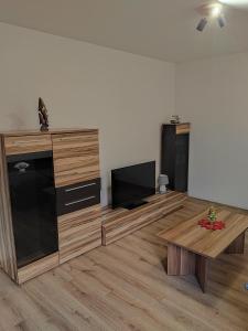 een woonkamer met houten meubels en een flatscreen-tv bij APARTMÁN KATKA Liptovský Mikuláš in Liptovský Mikuláš +5 foto's
