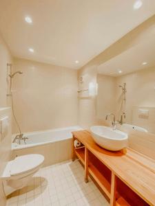 a bathroom with a sink and a tub and a toilet at Charming Cabin Overlooking Vegglifjell in Kravikfjord +22 photos