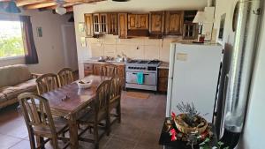 een keuken met een houten tafel en een koelkast bij Nativo Malbec in Ciudad Lujan de Cuyo