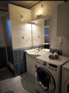 een badkamer met een wasmachine en een wastafel bij Bel Appartement Lumineux, 70m2, 3 Chambres, Proche Zénith et Hippodrome de Caen in Caen +7 foto's