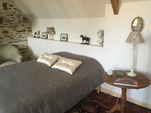 a bedroom with a bed and a table and a lamp at La Carbonnière in Condé-sur-Vire