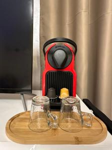 a coffee maker sitting on a table with two glasses at Marrakech Airport in Marrakesh