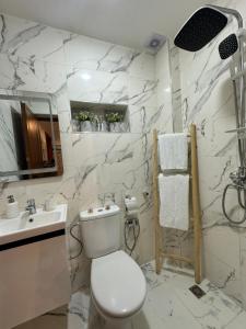 a white bathroom with a toilet and a sink at Marrakech Airport in Marrakesh