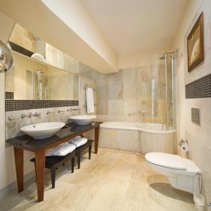 a bathroom with two sinks and a tub and a toilet at Mamaison Le Regina Boutique Hotel in Warsaw