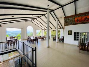 een grote woonkamer met een tafel en een eethoek bij Hotel H2O in Gampola