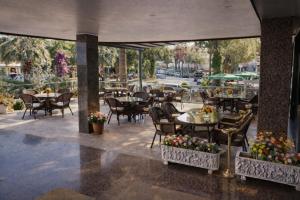 un patio extérieur avec des tables, des chaises, des tables et des chaises dans l'établissement Kayhanbey Hotel, à Kusadası