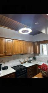 een keuken met houten kasten en een kookplaat met oven bij House by the Mountain in Konitsa