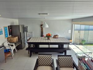a living room with a table and a kitchen at Casa completa Centro de Xangri-lá, perto do mar in Xangri-lá