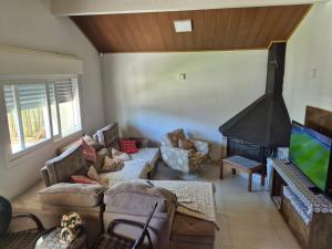 a living room with a fireplace and a tv at Casa completa Centro de Xangri-lá, perto do mar in Xangri-lá