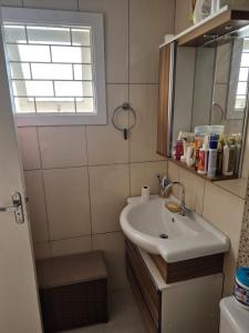 a bathroom with a sink and a mirror at Casa completa Centro de Xangri-lá, perto do mar in Xangri-lá +12 photos