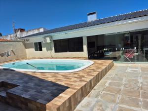 a swimming pool in the backyard of a house at Casa completa Centro de Xangri-lá, perto do mar in Xangri-lá