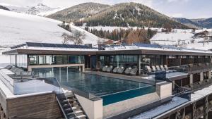 een huis met een zwembad in de sneeuw bij Terentnerhof 4*S active & lifestyle hotel in Terento