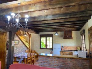 eine Küche mit einem Tisch und einer Ziegelwand in der Unterkunft Los Avellanos Casa 2 in Celis
