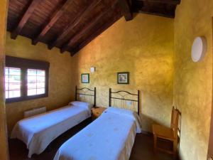 ein Schlafzimmer mit zwei Betten und einem Fenster in der Unterkunft Los Avellanos Casa 2 in Celis