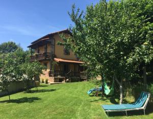 ein Haus mit einem Garten mit Stühlen davor in der Unterkunft Los Avellanos Casa 2 in Celis