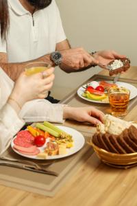 een groep mensen die aan een tafel zitten met eten bij Barca Hotel in Jerevan