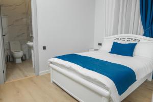 a white bed with blue pillows in a bedroom at Barca Hotel in Yerevan