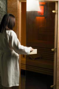 een vrouw staat voor een raam en houdt een stuk papier vast bij Barca Hotel in Jerevan +27 foto's