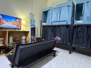 a room with a bed and a tv and a couch at Bed space for Budget Backpacker - No Parking in Abu Dhabi