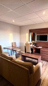 een woonkamer met een bank, een tafel en een tv bij The March Hotel in March