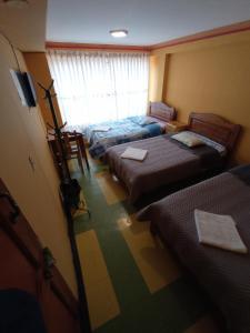 een kamer met vier bedden en een televisie. bij WILLKA Hostel in Copacabana