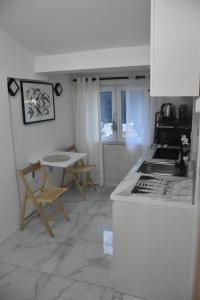 a kitchen with a counter and a table and chairs at Fiko Apartment in Niš