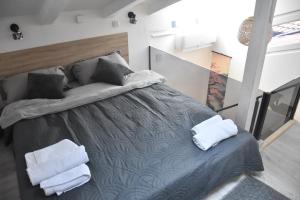 a bedroom with a bed with two towels on it at Fiko Apartment in Niš