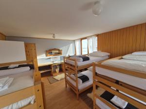 een kamer met 3 stapelbedden en een bureau bij Tignousa logement de groupes et individuels in Saint-Luc