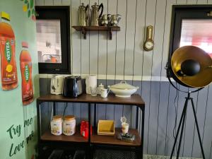 een kamer met een plank met kopjes en een klok bij Tignousa logement de groupes et individuels in Saint-Luc