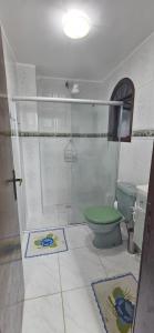 a bathroom with a shower and a green toilet at Flat Saigon Barra de Maricá Pé na Areia Wi-Fi in Maricá