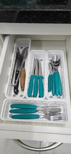 a plastic container filled with utensils in a drawer at Flat Saigon Barra de Maricá Pé na Areia Wi-Fi in Maricá