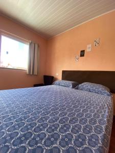een slaapkamer met een bed met een blauw dekbed en een raam bij Pousada Mont Hebrom in Ibicoara +22 foto's