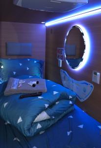 een slaapkamer met een bed en een ronde spiegel bij The GreenHouse Capsules in Londen