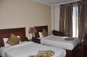 een hotelkamer met twee bedden met bogen erop bij Foyat Hotel in Addis Ababa