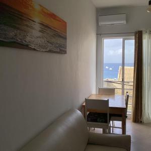 a living room with a table and a view of the ocean at Fort Apartments in Vila do Porto