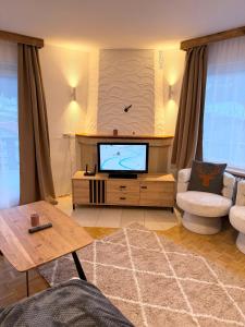 a living room with a flat screen tv and a couch at Gruber Alpin Living in Söll +17 photos