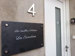 een bord met het nummer vier erop aan de zijkant van een gebouw bij Maison Les Escardines in Oye-Plage