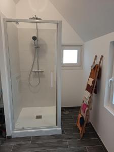 een douche met een glazen deur in een badkamer bij Maison Les Escardines in Oye-Plage