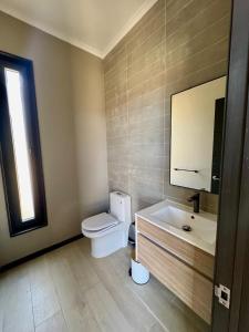 een badkamer met een toilet, een wastafel en een spiegel bij Casa en Maitencillo in Puchuncaví +21 foto's