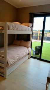 een slaapkamer met 2 stapelbedden en een glazen schuifdeur bij Casa en Maitencillo in Puchuncaví