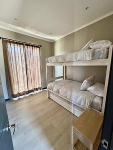 een slaapkamer met twee stapelbedden en een raam bij Casa en Maitencillo in Puchuncaví