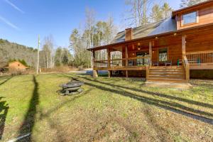 una baita di tronchi con una panchina di fronte ad essa di Riverfront Cabin with Mtn Views in Robbinsville a Junction