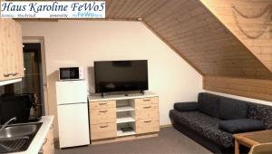 een woonkamer met een bank en een flatscreen-tv bij Haus Karoline FeWo5 in Hochrindl